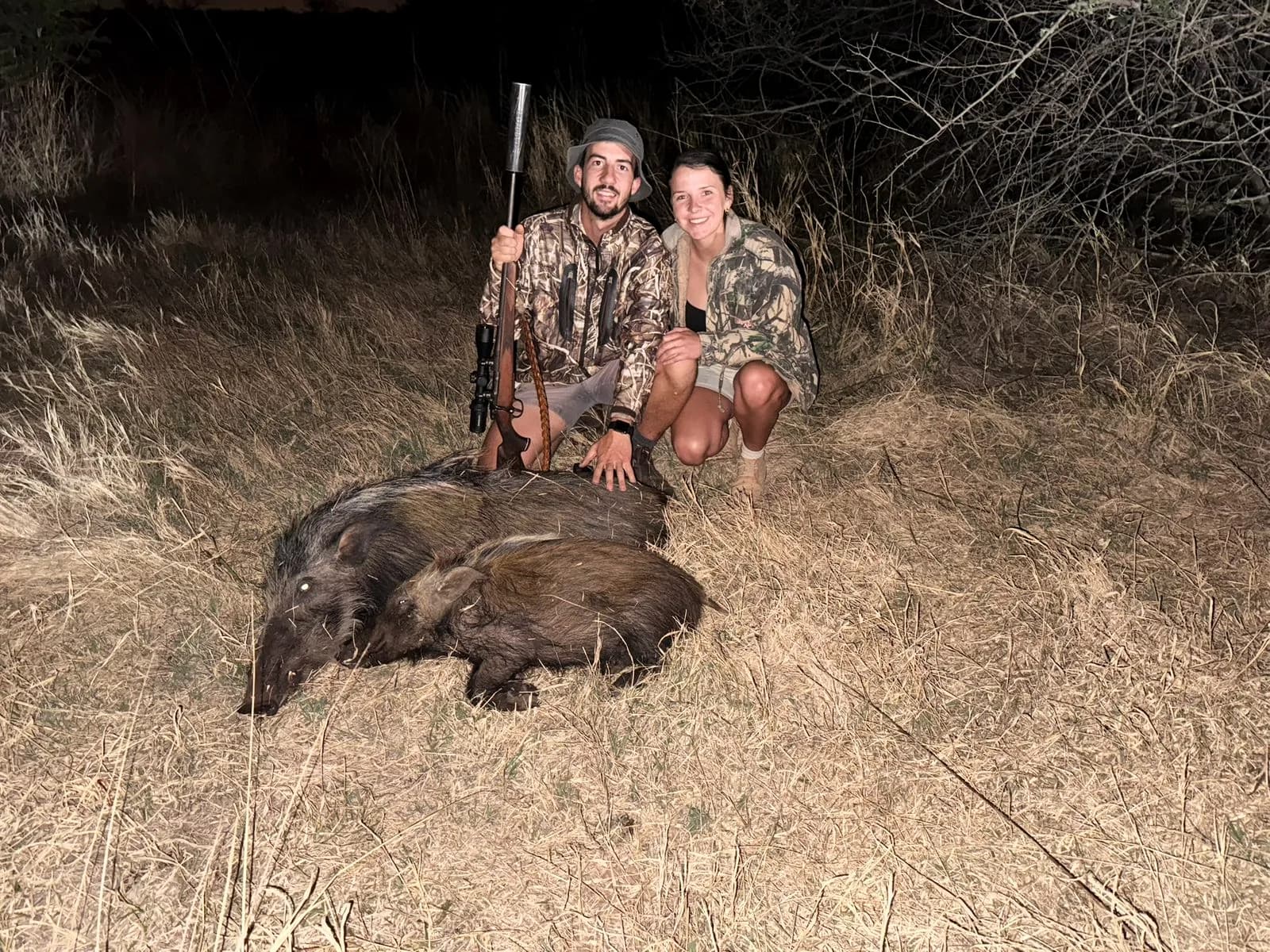 Two hunters with a pair of bushpig taken after dark